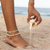 Compass Charm White Heishi Bead Anklet Stack on Beach Shell Pouring out Sand